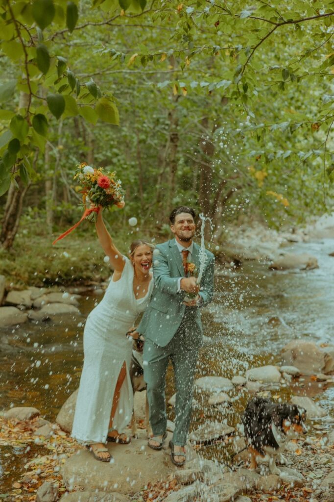 bride and groom popping champagne to celebrate their elopement