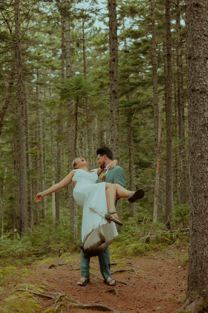groom twirling bride around at their maine elopement hike