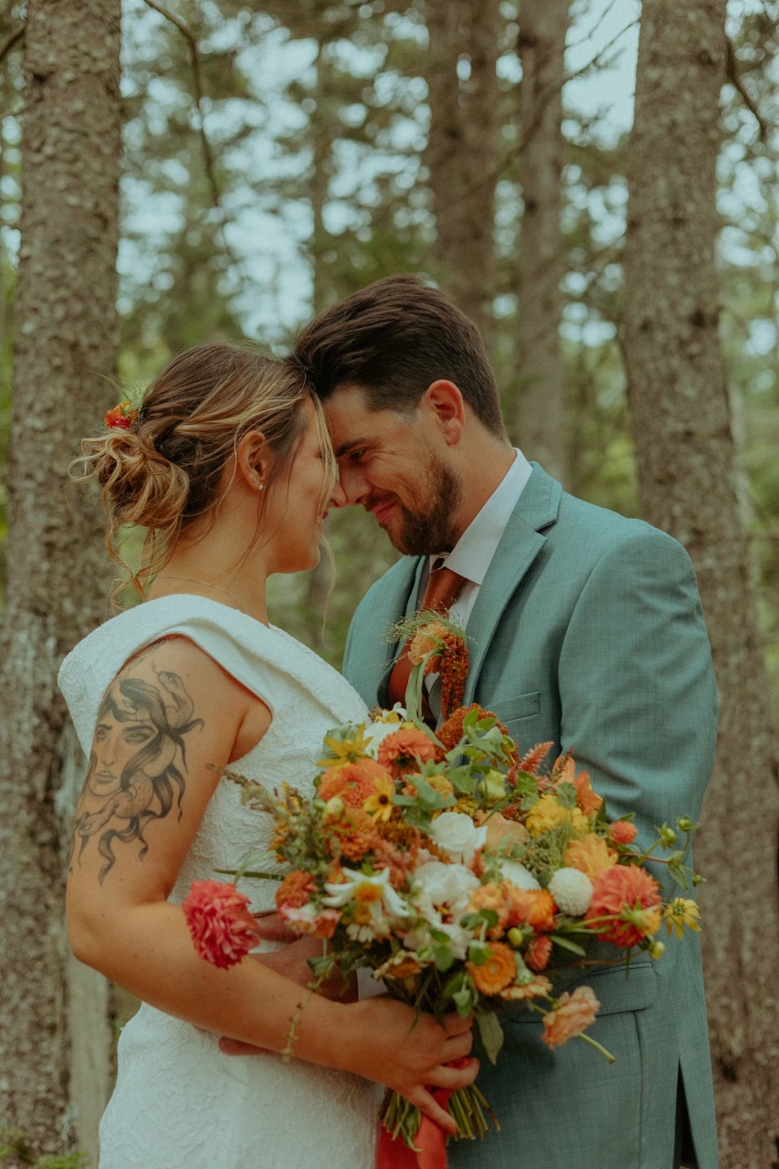 couple posing forehead to forehead for their elopement photos in the forest