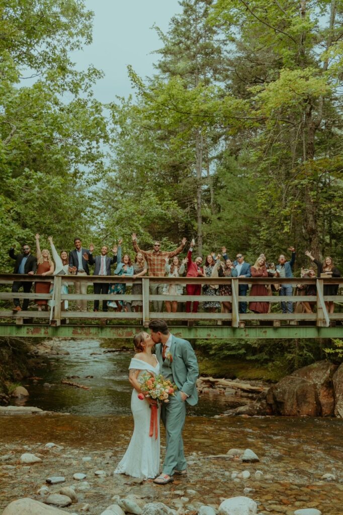 bride and groom kiss in front of guests at their maine elopement