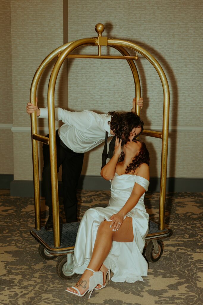 Man and woman posing on a luggage cart for Columbus ohio engagement session
