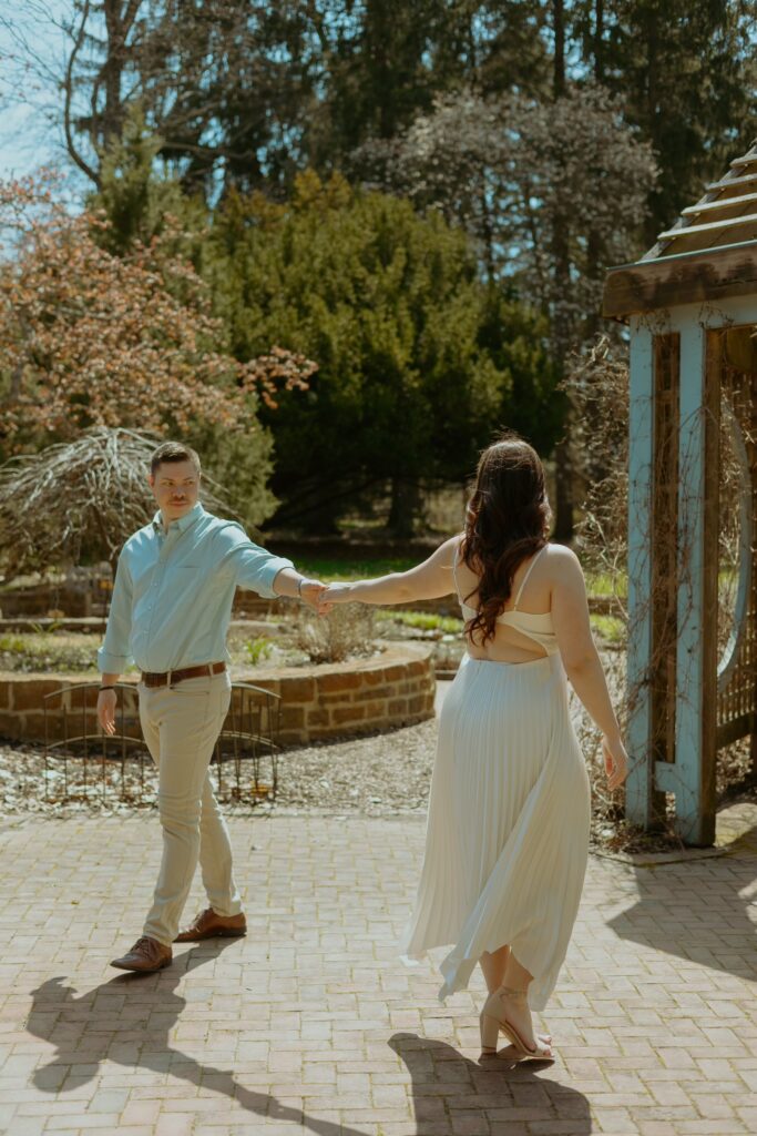 man and woman twirl together during their Columbus engagement session