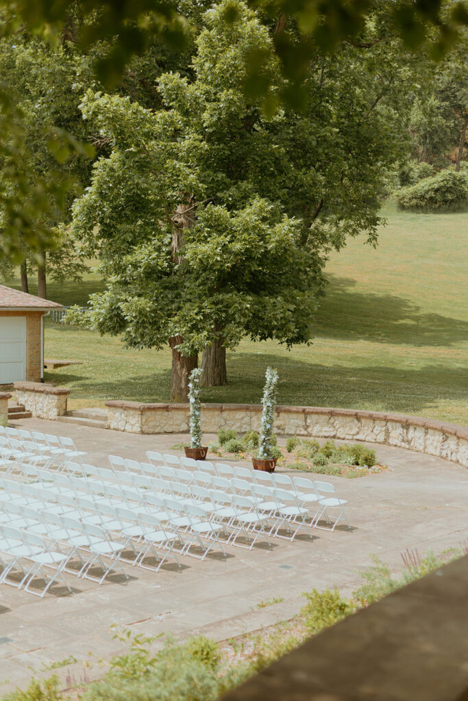 outdoor ceremony space of white chairs and greenery photographed by a Columbus wedding photographer