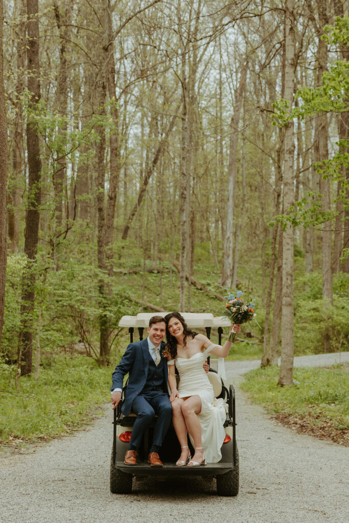 Man and woman riding away on a golf cart at their wedding