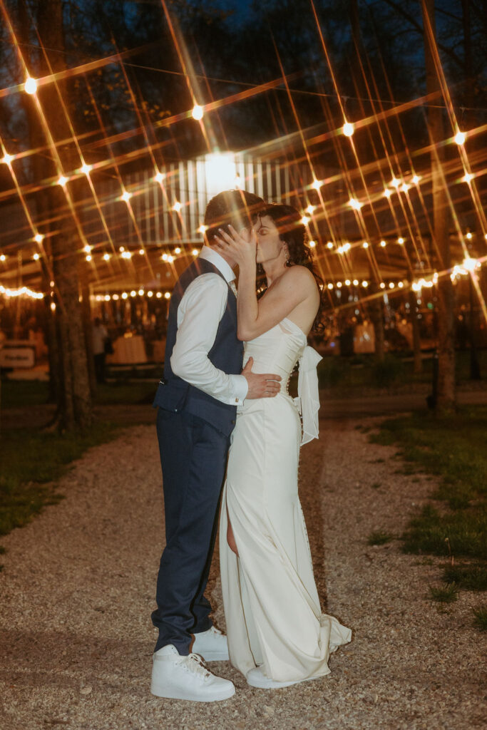 Couple kissing under string lights at The Brook