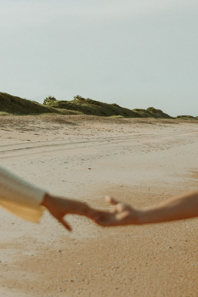 man and woman holding hands in front of St Augustine beaches landscape 