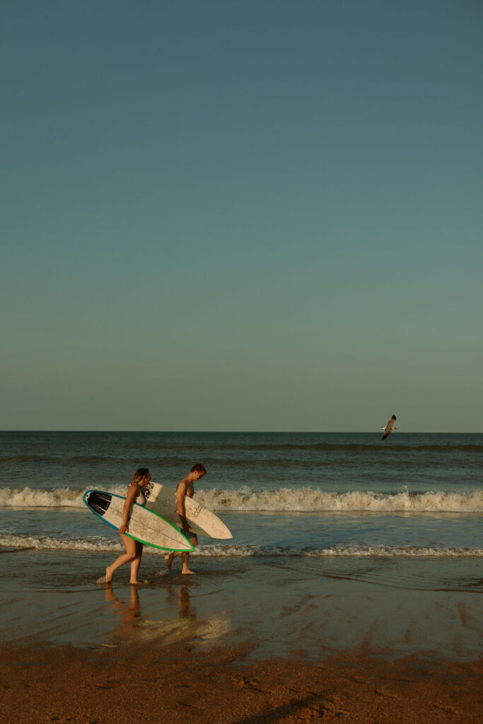 man and woman walking along St Augustine beach during sunset