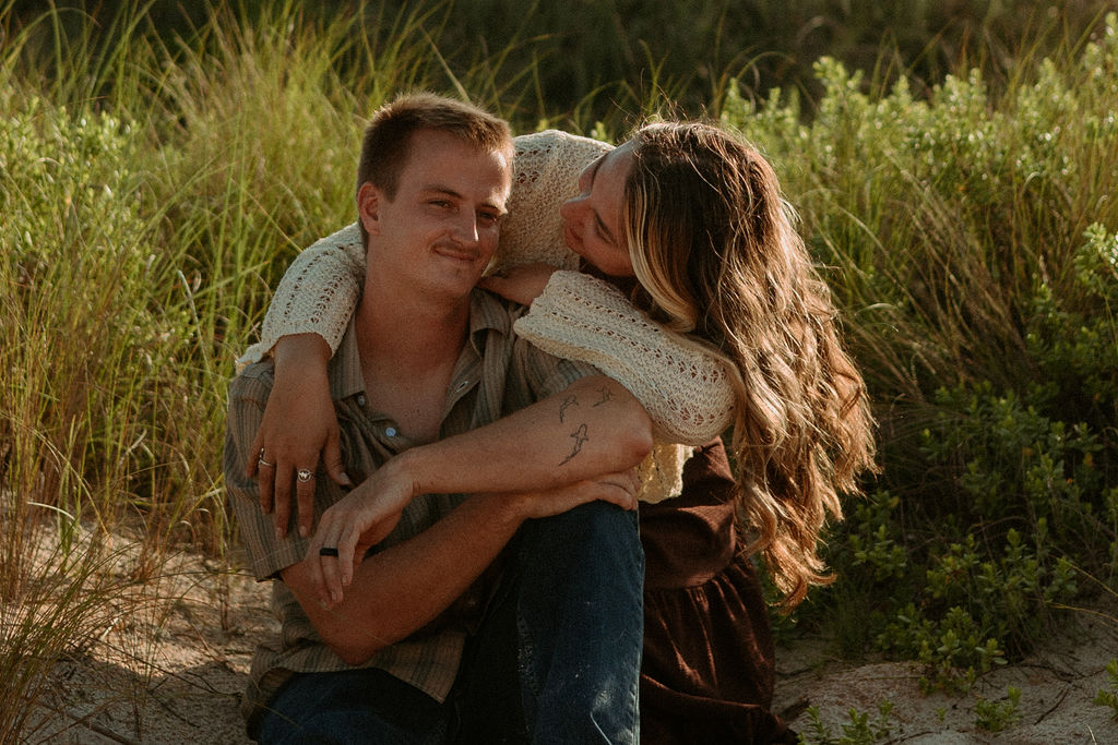 woman wrapped around a man sitting on St Augustine beach