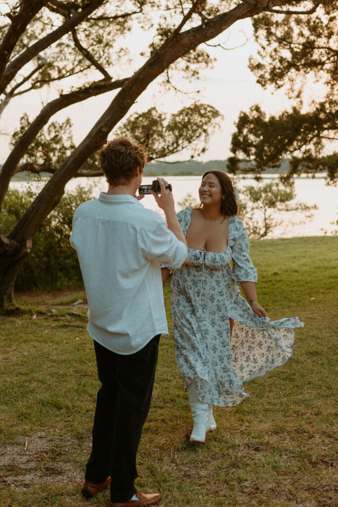 a man filming a woman twirling by the beach at Washington Oaks Gardens 