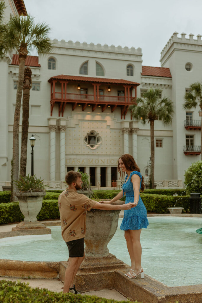 St Augustine couple holding hands by a fountain 