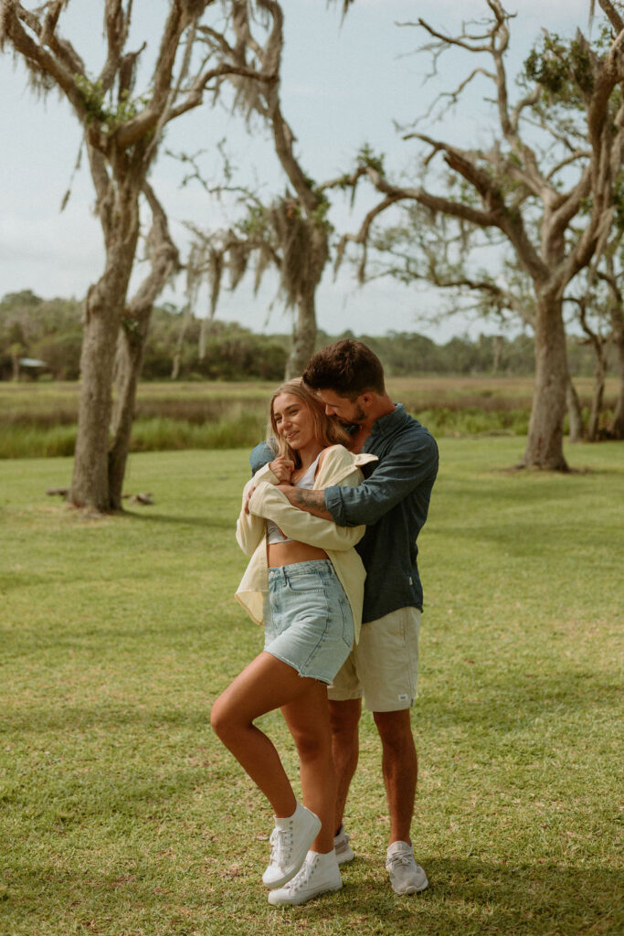 man hugging woman from behind in their St Augustine yard