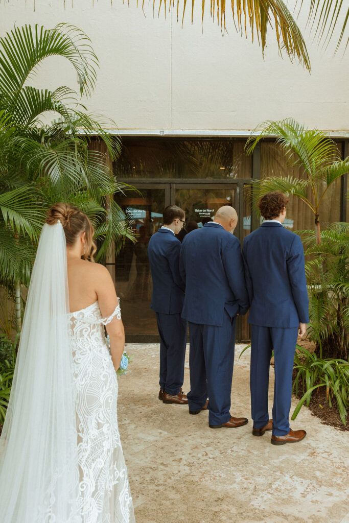 bride doing a first look with her dad and brothers 