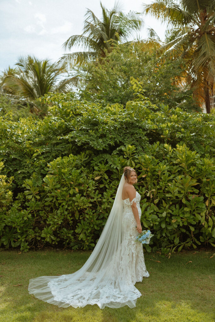 portrait of a bride standing outside by palm trees