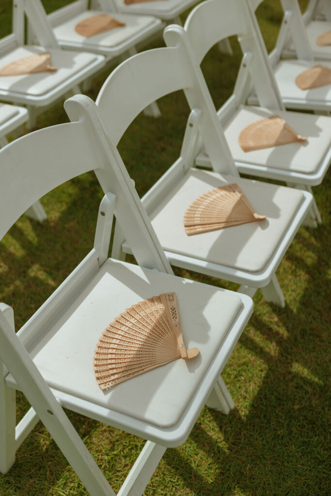 wooden fans placed on white chairs