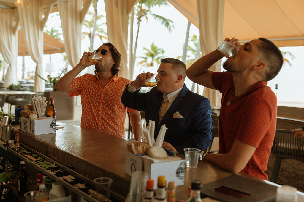 groom and friends taking a shot at the bar 