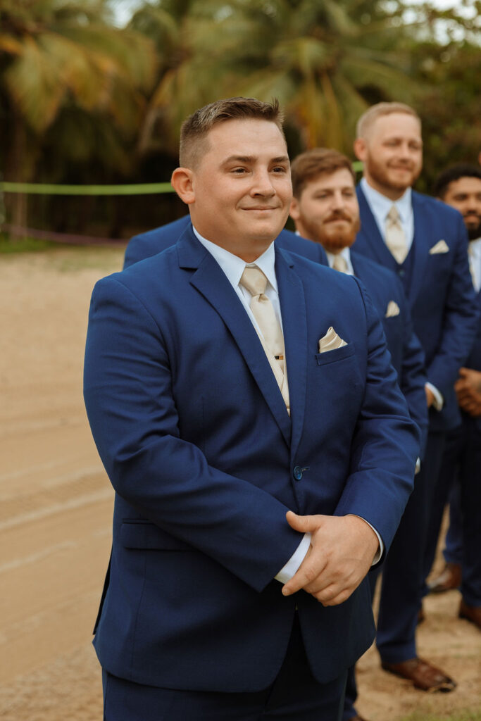 groom watching his bride walk down the aisle 