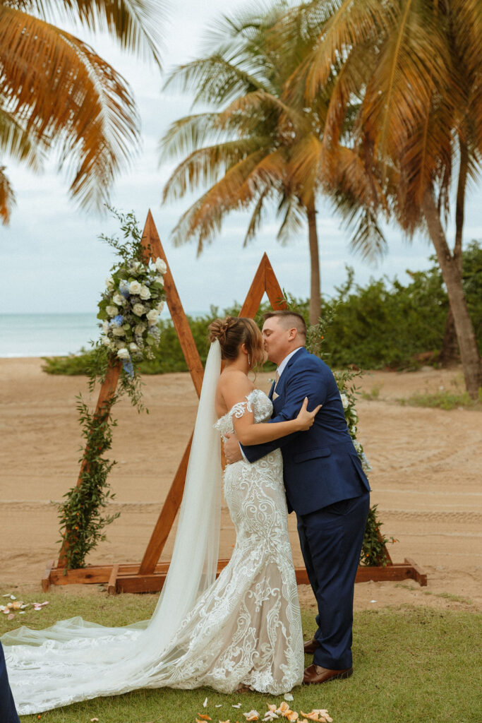 bride and groom kissing during their beach front ceremony