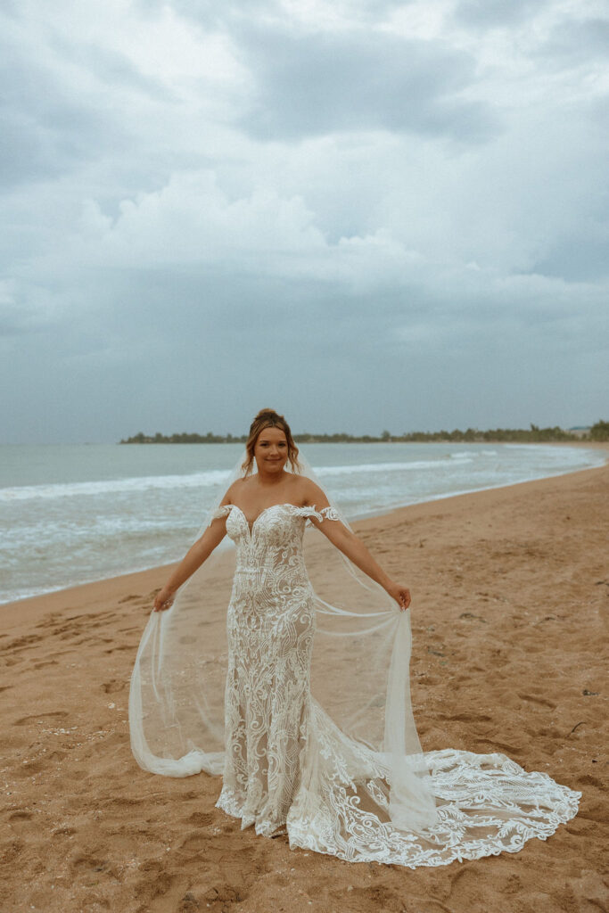 portrait of puerto rico bride twirling her dress in the sand 