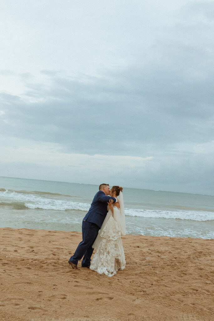 man embracing woman on the beach of their puerto rico wedding 