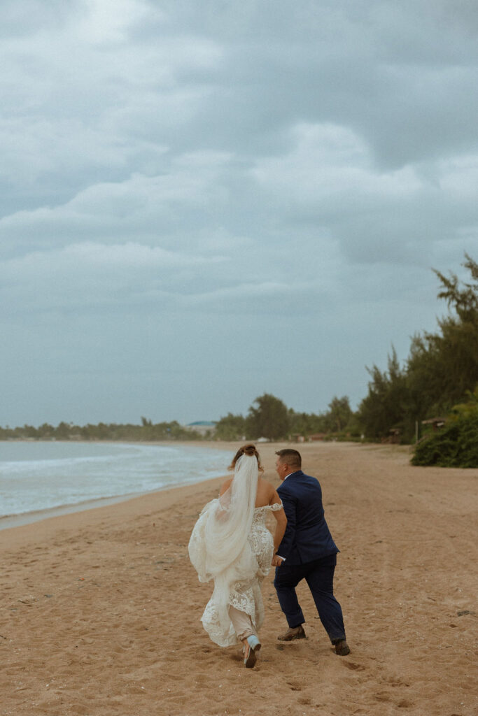 groom and bride running on the beach 