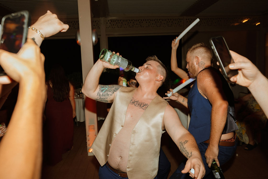 groom celebrating his puerto rico wedding reception with a drink