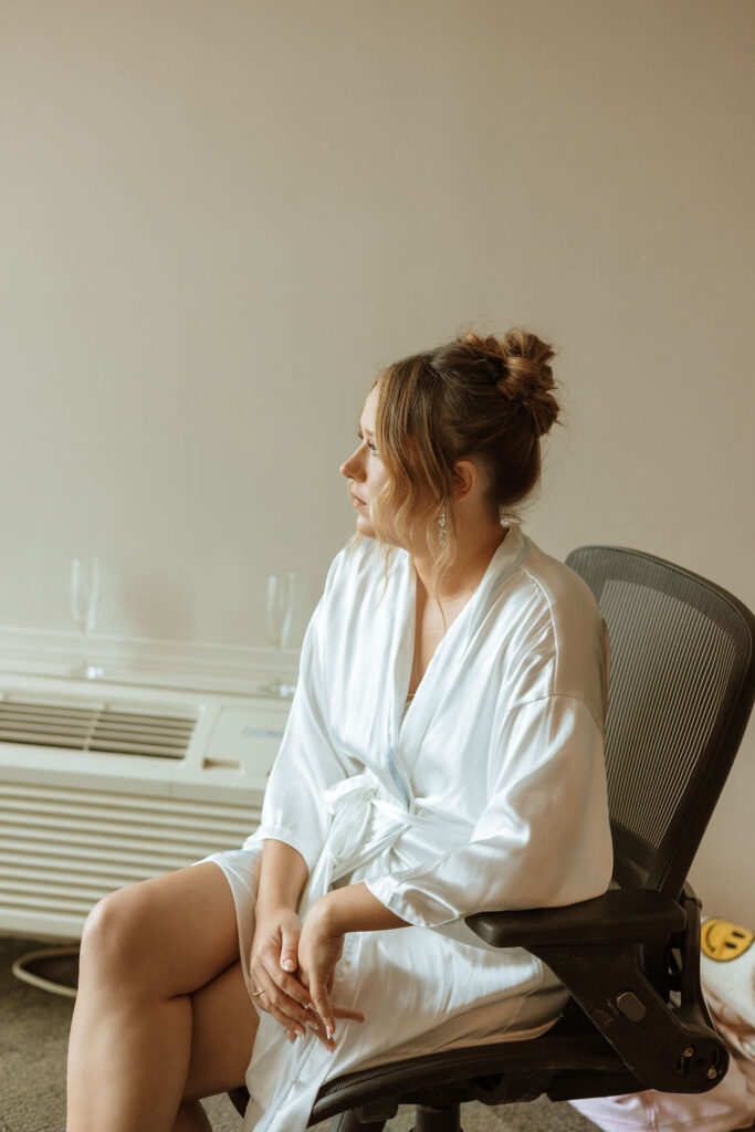 a bride sitting down in a chair wearing a robe