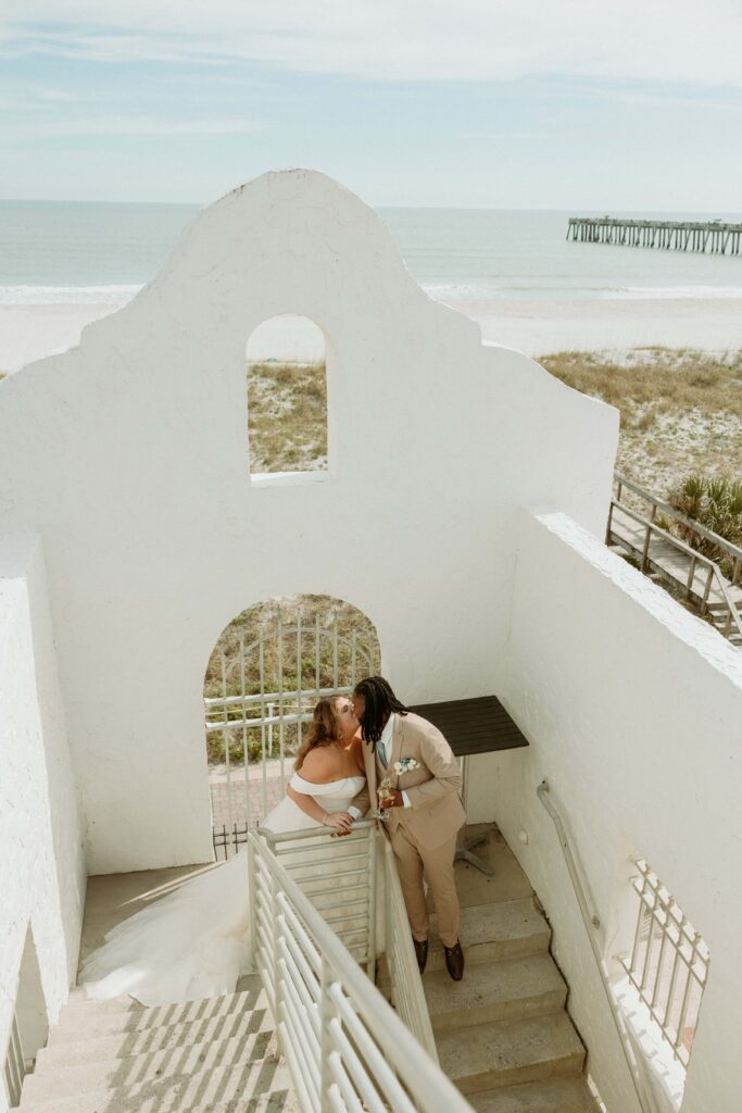 a couple kissing by the stairs after they eloped