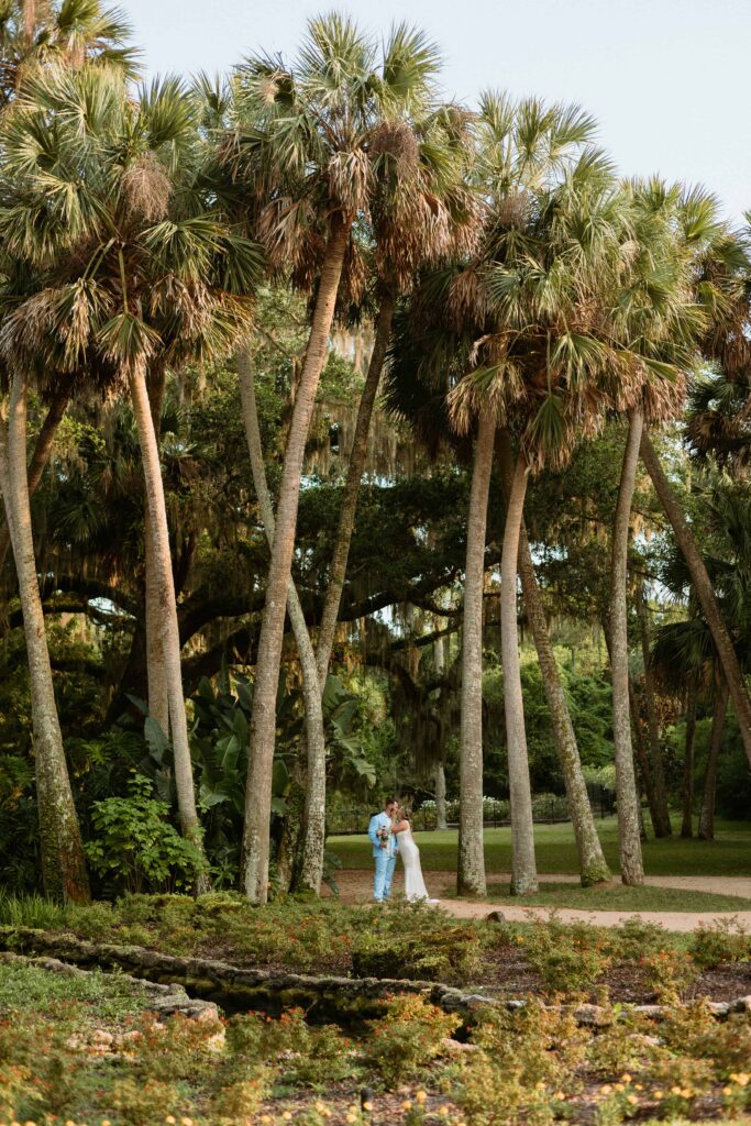 couple kissing amongst tall palm trees in Florida for their elopement