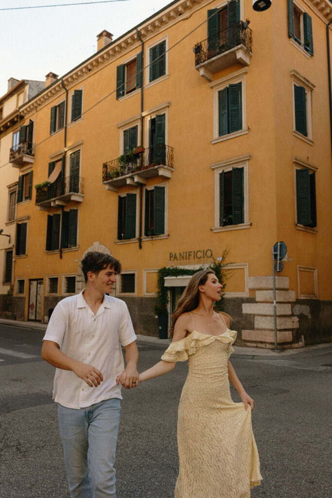 Couple running across the road in Verona during their engagement session