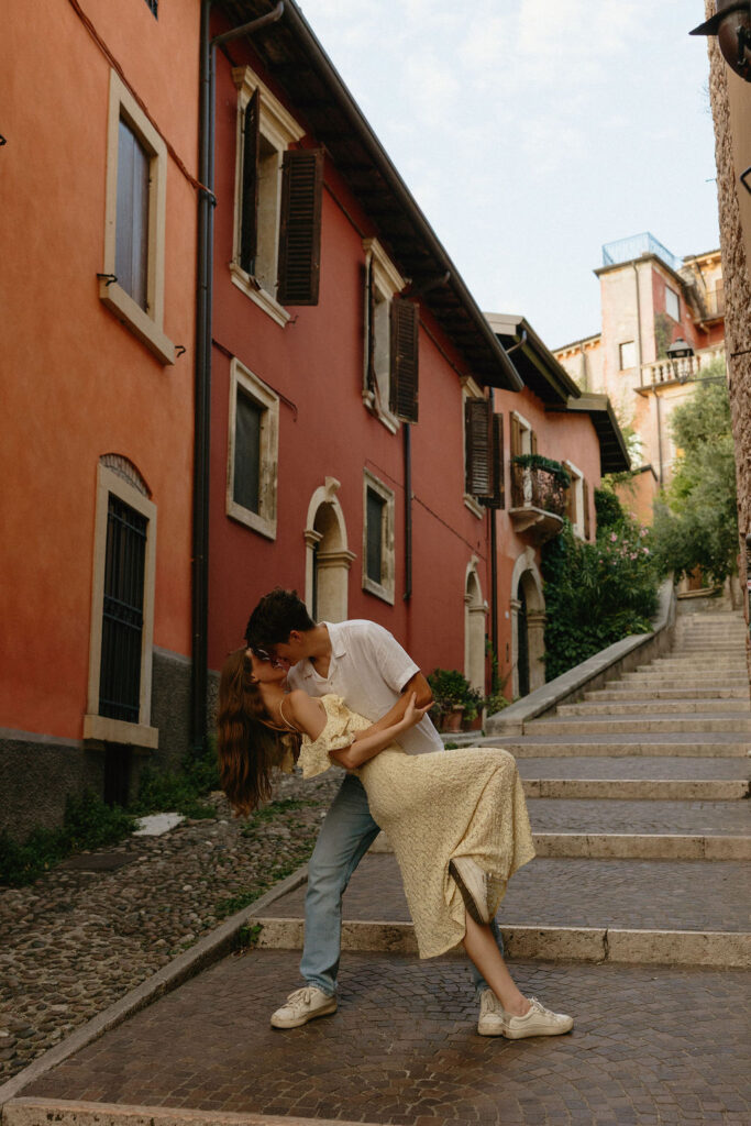 Man dipping his Fiance on the cobblestone street in Verona for a photoshoot