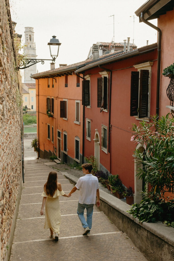 Verona, Italy engagement photos of a man and woman walking down the street