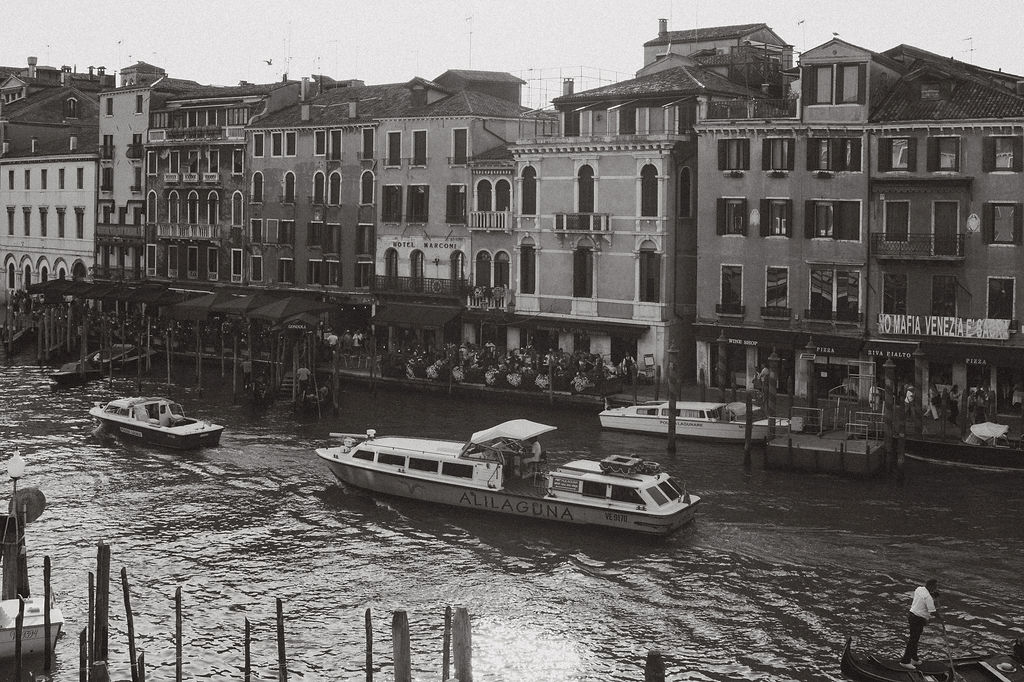 Boats traveling along a Venetian canal showcased in a Venice travel guide