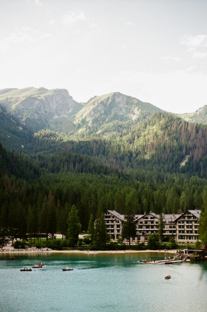 Wooden boathouse on Lago di Braies with turquoise alpine lake and mountains