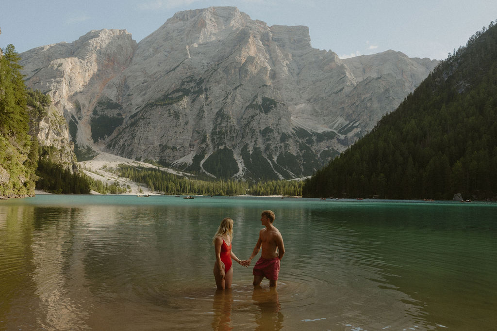 Couple wading in Lago di Braies with mountain views