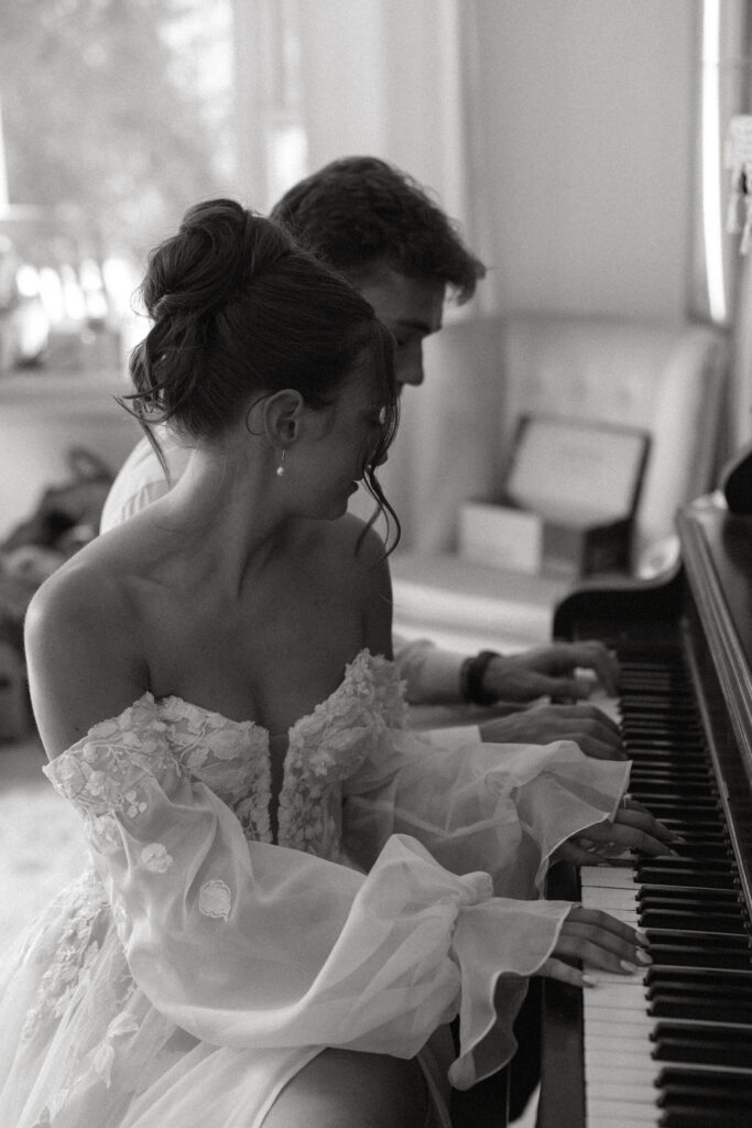 Bride and groom playing piano together before their Magnolia Spring Farm ceremony