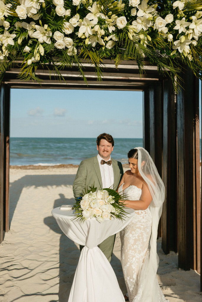 Bride and groom signing their marriage license during their Secrets Playa Blanca beach ceremony