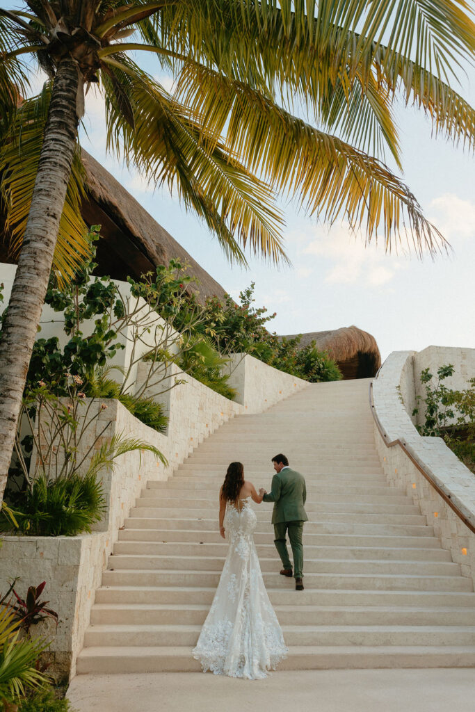 Groom and bride walking up the stairs at Secrets Playa Blanca in Cancun Mexico 