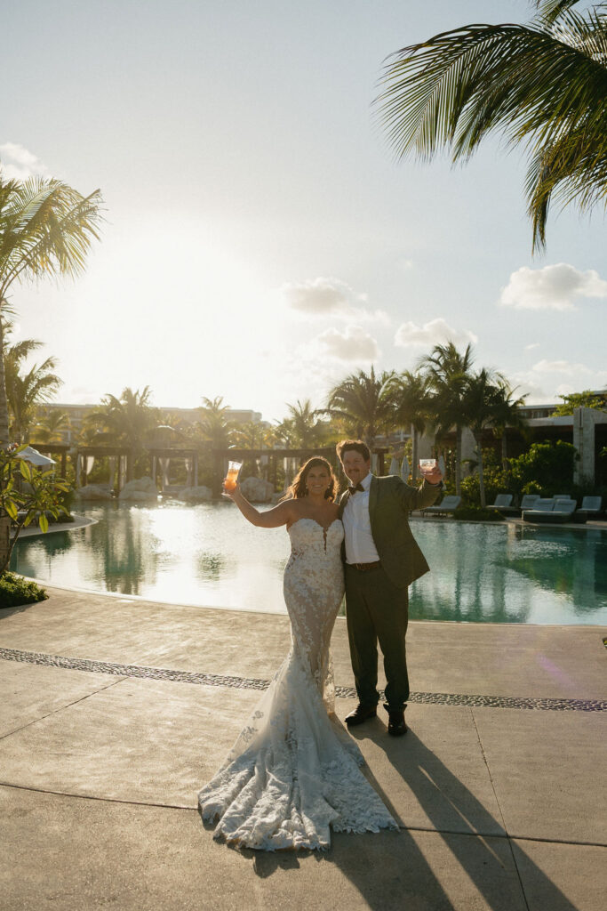 Groom and bride cheers by the pool at Secrets Playa Blanca in Mexico 