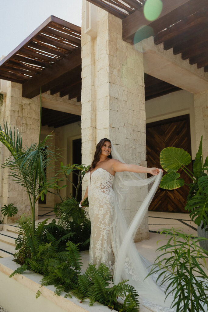 Bridal portraits of a bride swaying her veil on her wedding day at Secrets Playa Blanca