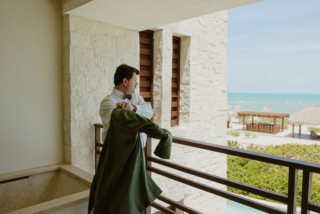 Groom getting ready on a balcony in Secrets Playa Blanca