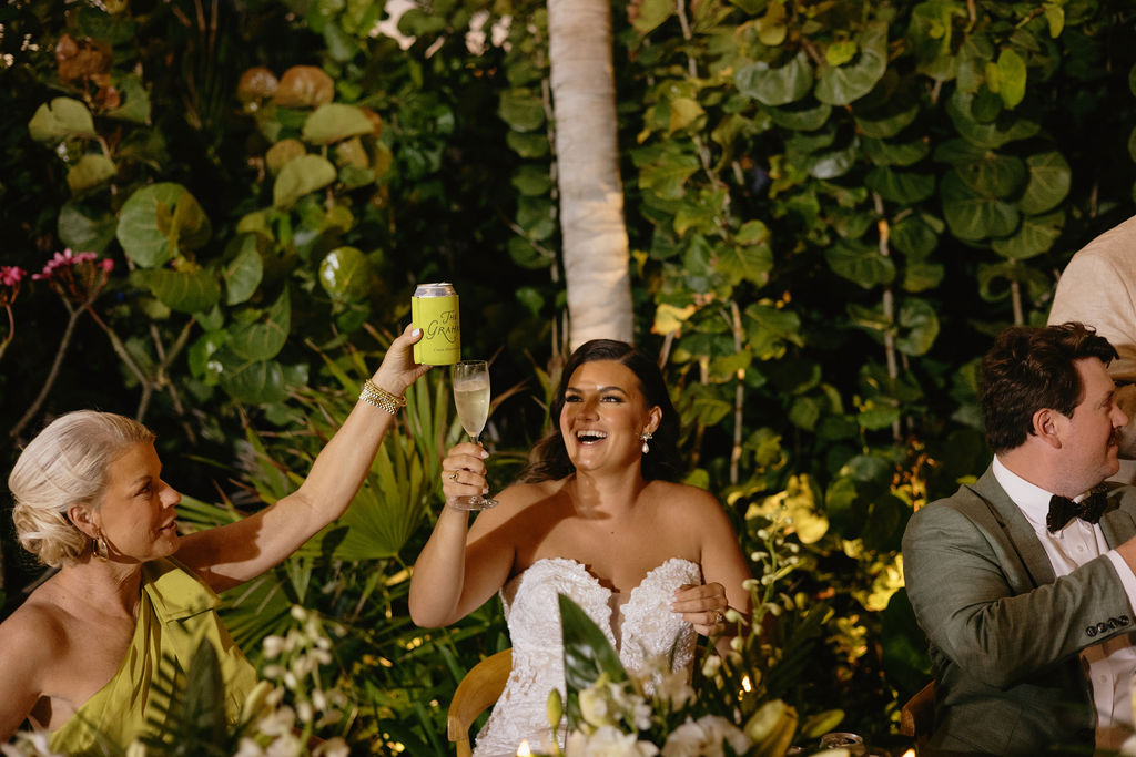 Bride and mom cheers during a family speech at her Secrets Playa Blanca wedding