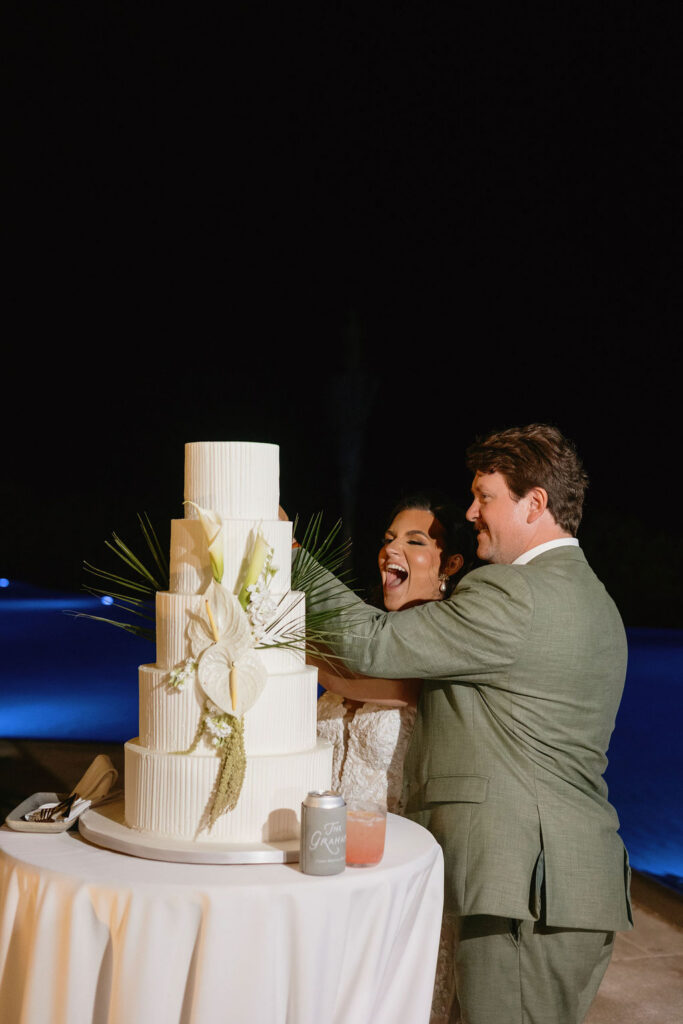 Couple cutting the cake by the pool at the Secrets Playa Blanca resort